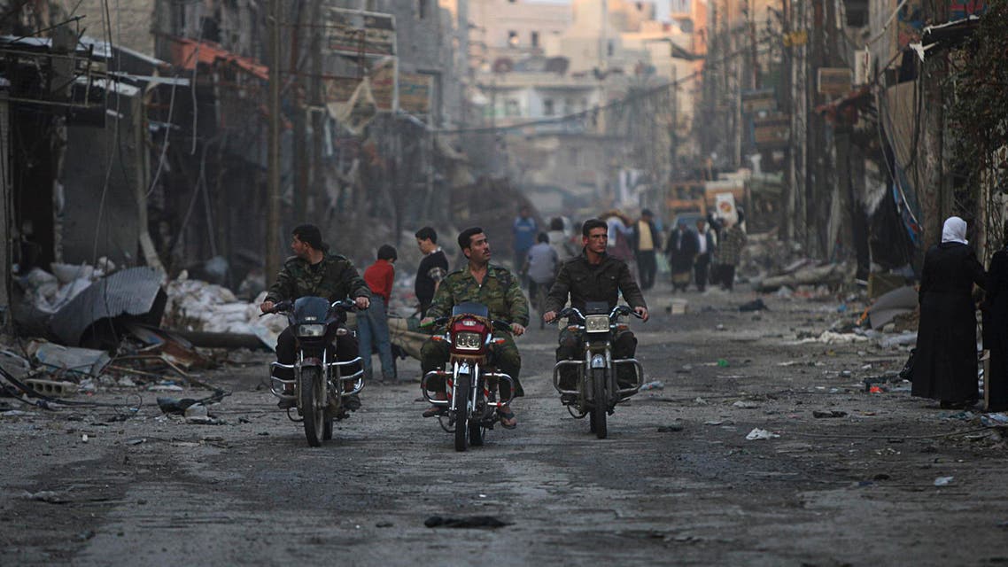 Security personnel loyal to Syria's President Bashar al-Assad ride motorcycles along a deserted street in Hujaira town, south of Damascus Nov. 21, 2013. (Reuters)