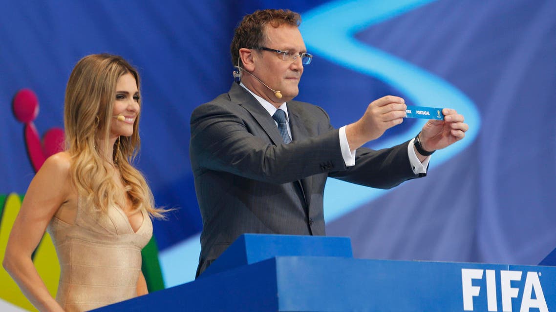 FIFA Secretary General Jerome Valcke holds up the slip showing "Portugal" next to presenter Fernanda Lima during the draw for the 2014 World Cup at the Costa do Sauipe resort in Sao Joao da Mata, Bahia state, December 6, 2013.