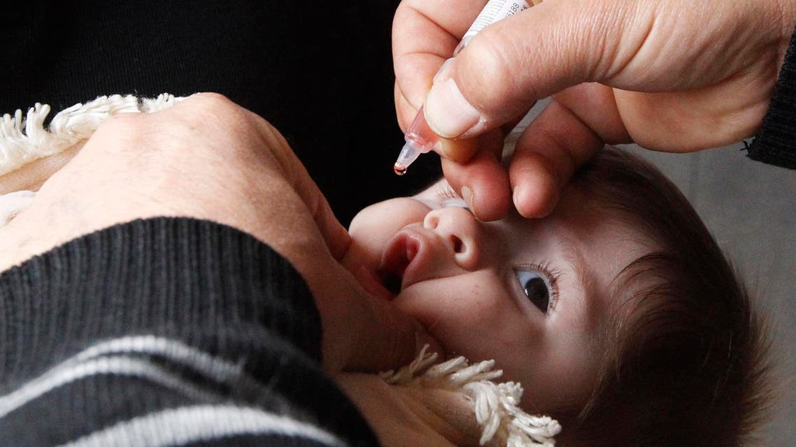 A health worker administers polio vaccination to a child in Raqqa, eastern Syria November 18, 2013. reuters