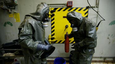 Workers dressed in protective clothing prepare a dummy chemical grenade for destruction at the Society for the Disposal of Chemical Weapons and Ordnance. (File photo: Reuters)