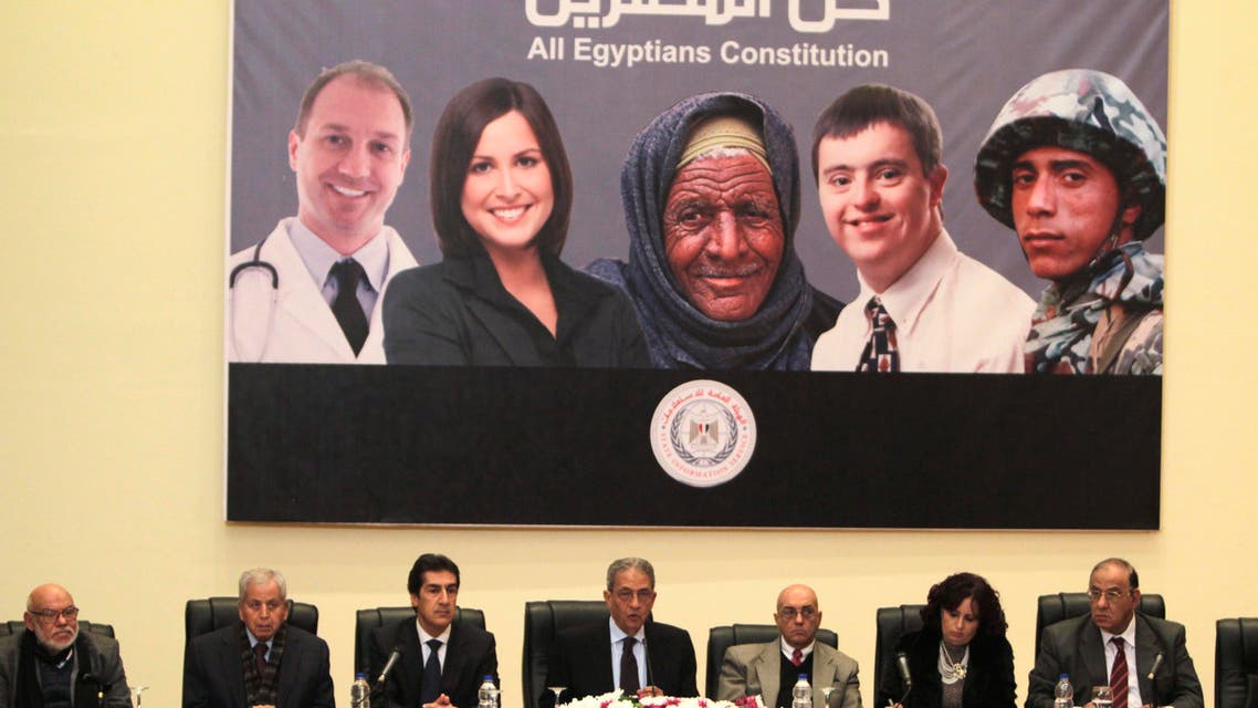Egypt's constituent assembly Chairman Amr Moussa (C) sits at a news conference. Behind him a poster riddled with mistakes. (Reuters)
