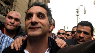 Bassem Youssef gestures to journalists and activists as he arrives to appear at the prosecutor's office in Cairo in March 31, 2013. (File photo: Reuters)