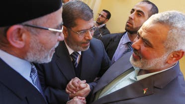 Senior Hamas leader Ismail Haniyeh (R) shakes hands with Mohamed Mursi (C), Egypt’s ousted president, and Egyptian Muslim brotherhood leader Mohammed Badie before an earlier meeting in Cairo. (File photo: Reuters)