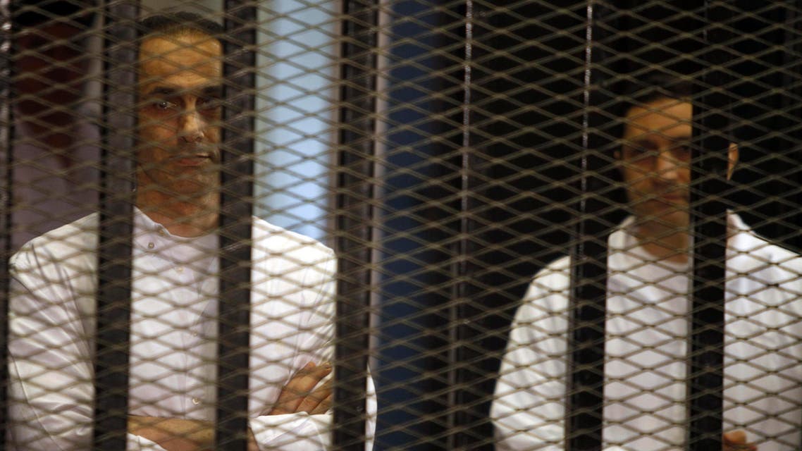 Gamal (L) and Alaa Mubarak, sons of former Egyptian President Hosni Mubarak, stand behind bars during a court trial on June 8, 2013. (File photo: Reuters)