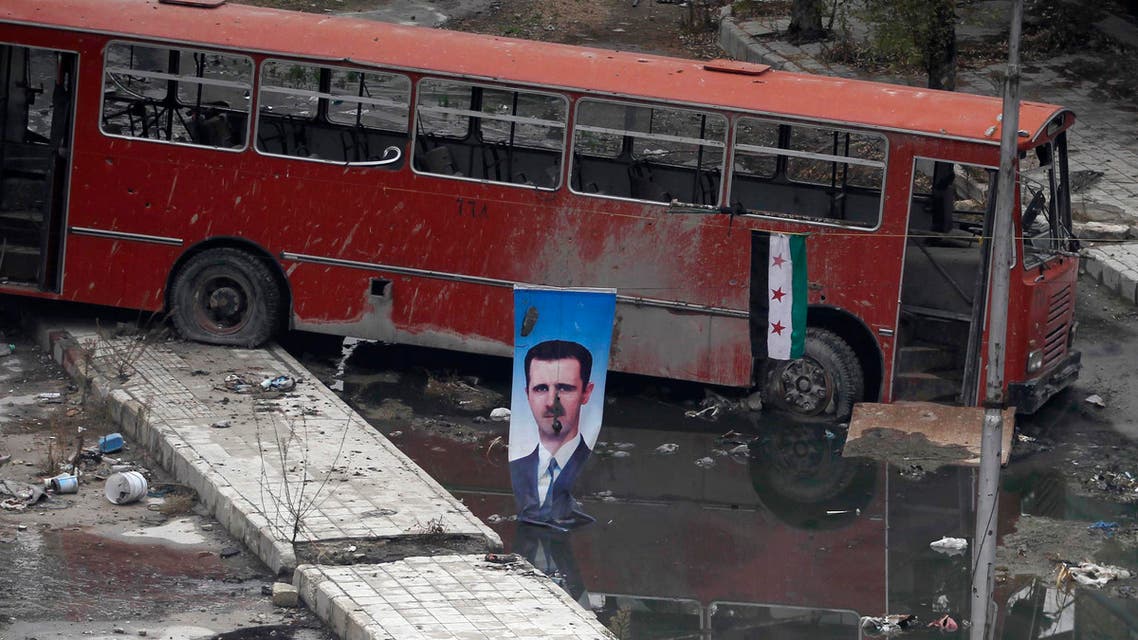 A picture of Syrian President Bashar al-Assad is seen near a Syrian opposition flag in Aleppo’s Bustan al-Basha district on Dec. 3. (File photo: Reuters)