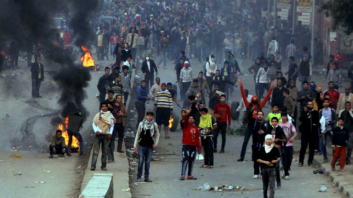 Supporters of the Muslim Brotherhood and ousted Egyptian President Mohammad Mursi gesture near burning tires during clashes with riot police in Cairo Dec. 20, 2013. (Reuters)