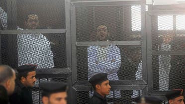 Political activists Ahmed Maher (R), Ahmed Douma (C) and Mohamed Adel, founder of 6 April movement, look on from behind bars in Abdeen court in Cairo, December 22, 2013. Reuters