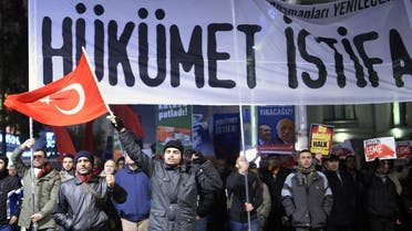 A demonstrator waves a Turkish flag as others hold a banner reading "government resign" during a protest against corruption in the Kadikoy district of Istanbul on December 25, 2013. Reuters