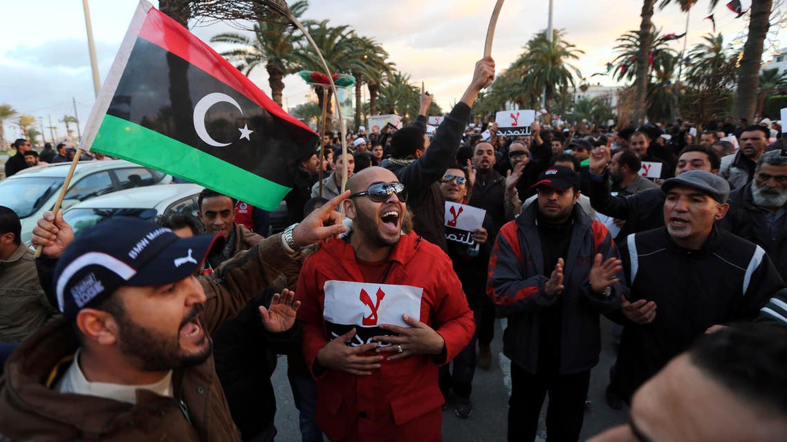 Libyan protestors hold placards as they demonstrate against the extended mandate of the General National Congress, the country's highest political authority, in Tripoli's Martyr square, on December 27, 2013. (AFP)