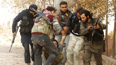 Free Syrian Army fighters carry a fellow fighter who was wounded during clashes with forces loyal to Syria's President Bashar al-Assad near Base 80 near Aleppo International airport, November 8, 2013