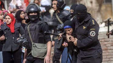 An Egyptian riot policeman detains a female student of al-Azhar University during a protest by students who support the Muslim Brotherhood inside their campus in Cairo on Dec, 30, 2013. (AFP)