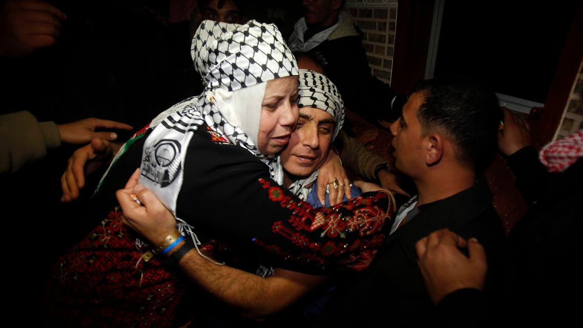 Freed Palestinian prisoner Rami Barbakh (C), who was held by Israel for 20 years, is hugged by his mother upon his release, in Khan Younis in the southern Gaza Strip December 31, 2013.