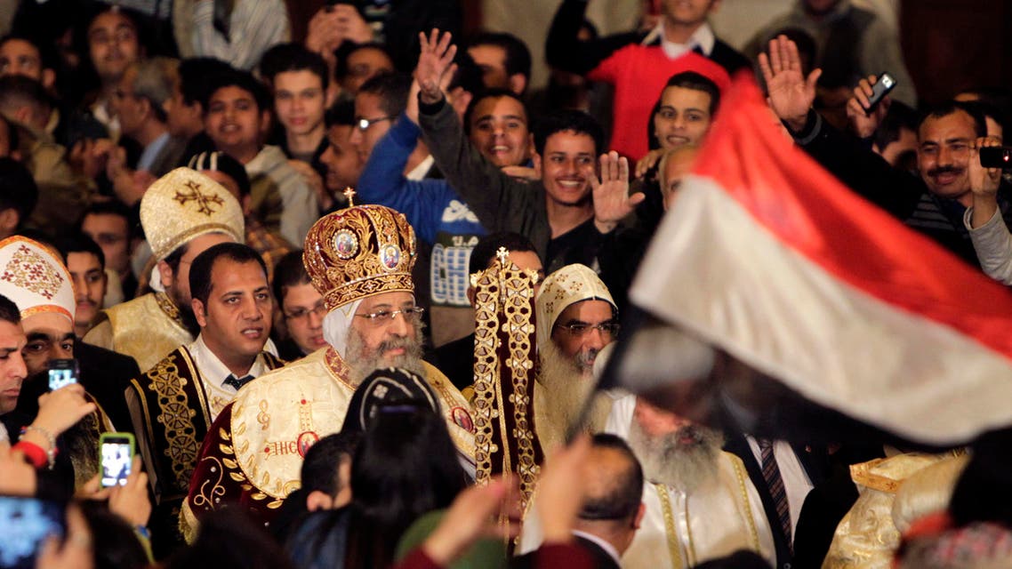 Egyptian Coptic Christians wave to Pope Tawadros II, the 118th Pope of the Coptic Orthodox Church of Alexandria and Patriarch of the See of St. Mark Cathedral, as they attend the Coptic Christmas Eve Mass in Cairo January 6, 2014.