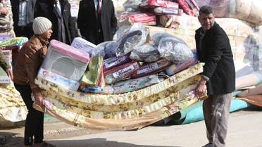 Sunni Muslim Iraqis who fled Fallujah with their families carry blankets and mattresses distributed by the International Organization for Migration (IOM) NGO in Ayn al-Tamer in Karbala province. (File photo: AFP)