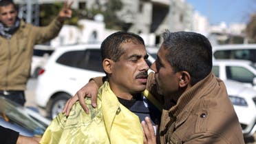 A Palestinian man (L) is hugged by a relative after he was freed from a Hamas-run jail in Gaza City, on January 8, 2014. (AFP)