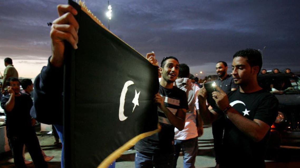 Libyan protesters hold the flag of the eastern Cyrenaica region during a demonstration calling for greater autonomy in the eastern city of Benghazi