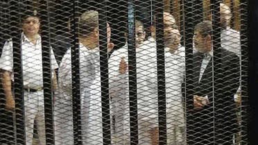 Ousted former Egyptian president Mohamed Mursi (R) speaks with other senior figures of the Muslim Brotherhood in a cage in a courthouse on the first day of his trial, in Cairo, November 4, 2013. (Reuters)