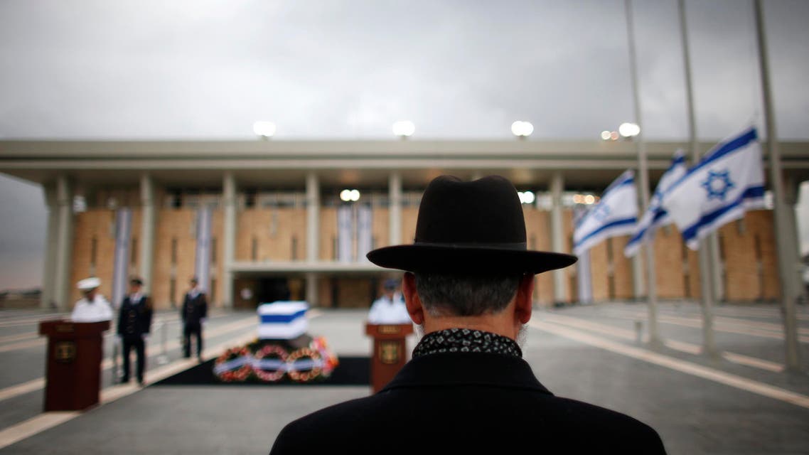 A man stands in front of the flag draped coffin of former Israeli Prime Minister Ariel Sharon outside the Knesset in Jerusalem January 12, 2014. reuters