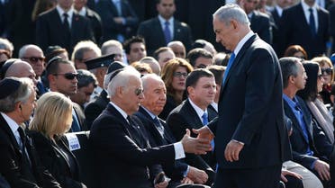 Israel's Prime Minister Benjamin Netanyahu (standing) shakes hands with U.S. Vice President Joe Biden during a memorial ceremony for the former Israeli prime minister Ariel Sharon at the Knesset, Israel's parliament, in Jerusalem January 13, 2014.