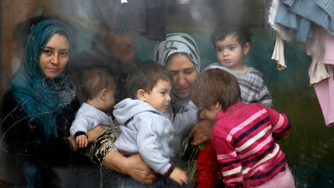 Syrian refugees look through a window inside a refugee centre as they wait for a distribution of humanitarian aid by volunteers of the Bulgarian Red Cross in Sofia reuters
