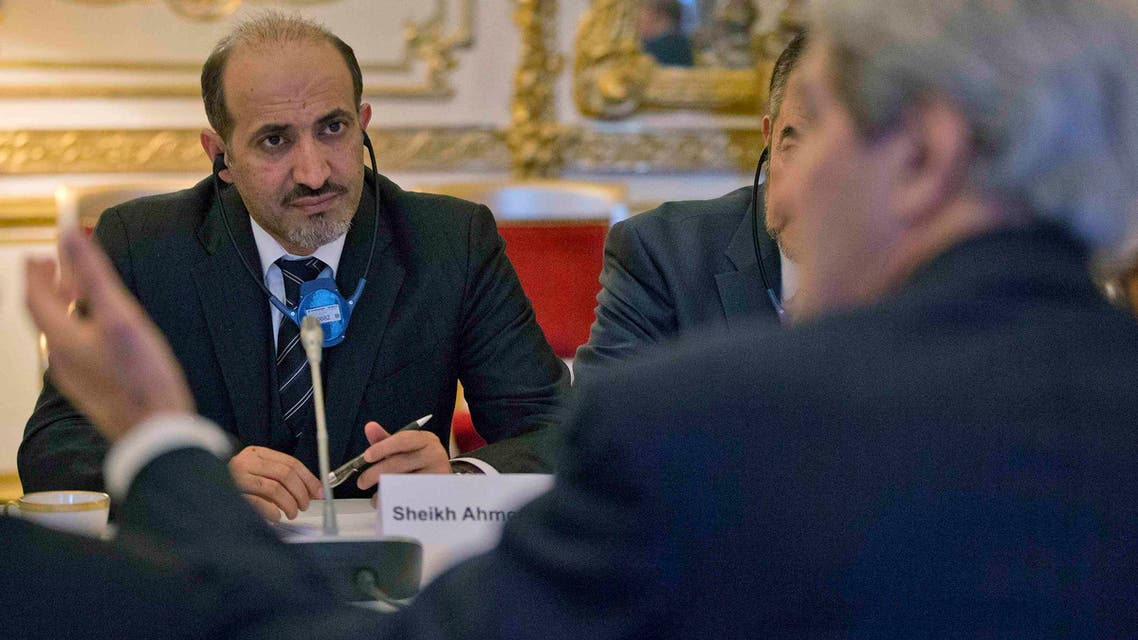 Syrian National Coalition Chief Ahmad al-Jarba (L) listens to U.S. Secretary of State John Kerry during the start of their meeting at the U.S. Ambassador residence in Paris January 13, 2014.