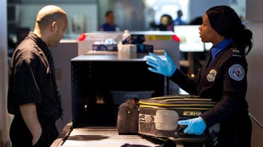 A Transportation Security Administration (TSA) security agent takes a traveler's luggage for a second security check at John F. Kennedy Airport in New York, Feb. 29, 2012. (Reuters)