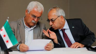 Abdelbasset Sida, leader of the opposition Syrian National Council (R), chats with council member George Sabra 