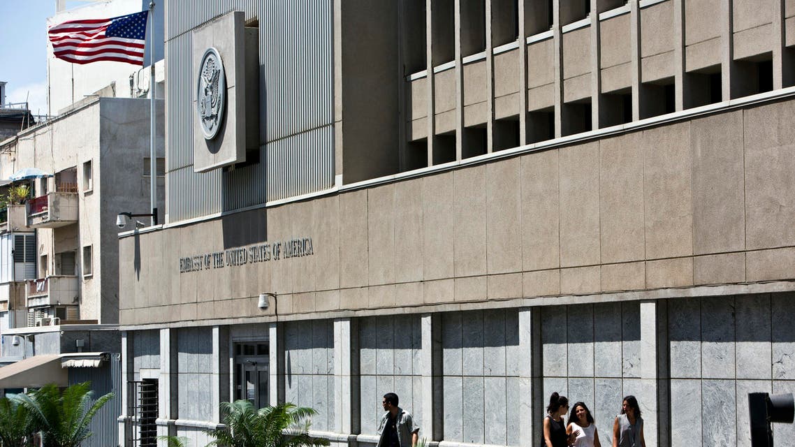 A security personnel stands outside the U.S. embassy in Tel Aviv as pedestrians walk past Aug. 4, 2013. (Reuters)