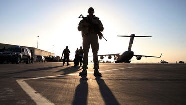 A U.S. soldier stands guard near a C-17 Globemaster III aircraft sitting on the tarmac at Kandahar Air Base Dec. 8, 2013. (Reuters)