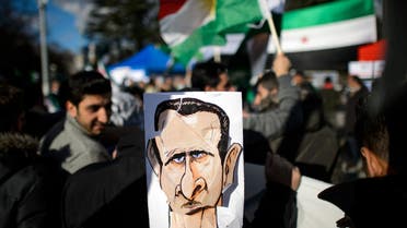 Demonstrators hold a sketch depicting Syrian President Bashar al-Assad during a protest against his regime outside the United Nations offices in Geneva on January 24, 2014.  afp