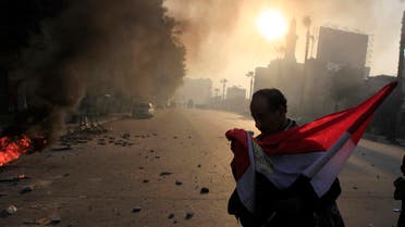 Anti-government protester holds a national flag during clashes at Ramsis street, which leads to Tahrir Square in downtown Cairo, on the third anniversary of Egypt's uprising, January 25, 2014. (Reuters)