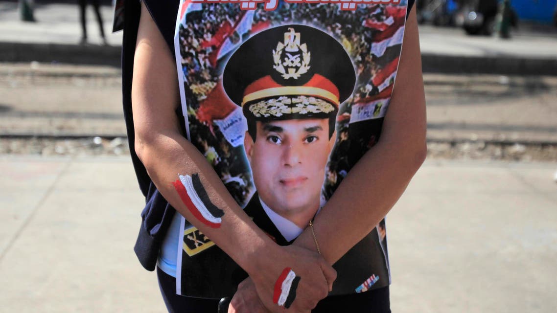 A supporter of Egypt's army chief General Abdel Fatah al-Sisi hugs his poster during celebrations of the third anniversary of Egypt's uprising, in front of El-Thadiya presidential palace in Cairo January 25, 2014.