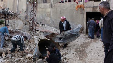 Residents inspect a site hit by shelling fired from Syria into the Lebanese village of Mashta Hammoud in Akkar January 31, 2014.