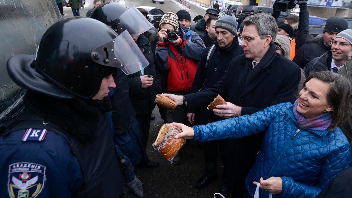 U.S. Assistant Secretary of State for European and Eurasian Affairs Victoria Nuland (R) and U.S. Ambassador Geoffrey Pyatt (2nd R) distribute bread to riot police near Independence square in Kiev Dec. 11, 2013. (Reuters)