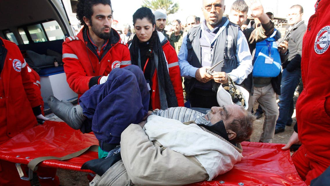 Members of the Syrian Arab Red Crescent assist a wounded man evacuated from a besieged area of Homs. (Reuters)