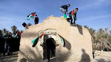 Palestinian and foreign activists hold Palestinian flags as they climb on top of a structure in an old village known as Ein Hajla, in the Jordan Valley near the West Bank city of Jericho Jan. 31, 2014. (Reuters)