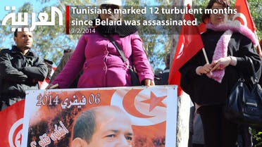 A Tunisian woman holds a placard with a portrait of murdered opposition figure Chokri Belaid outside El-Jellaz cemetery in a suburb of Tunis, where people visit Belaid's grave, one year after he was buried on February 8, 2014. (AFP)