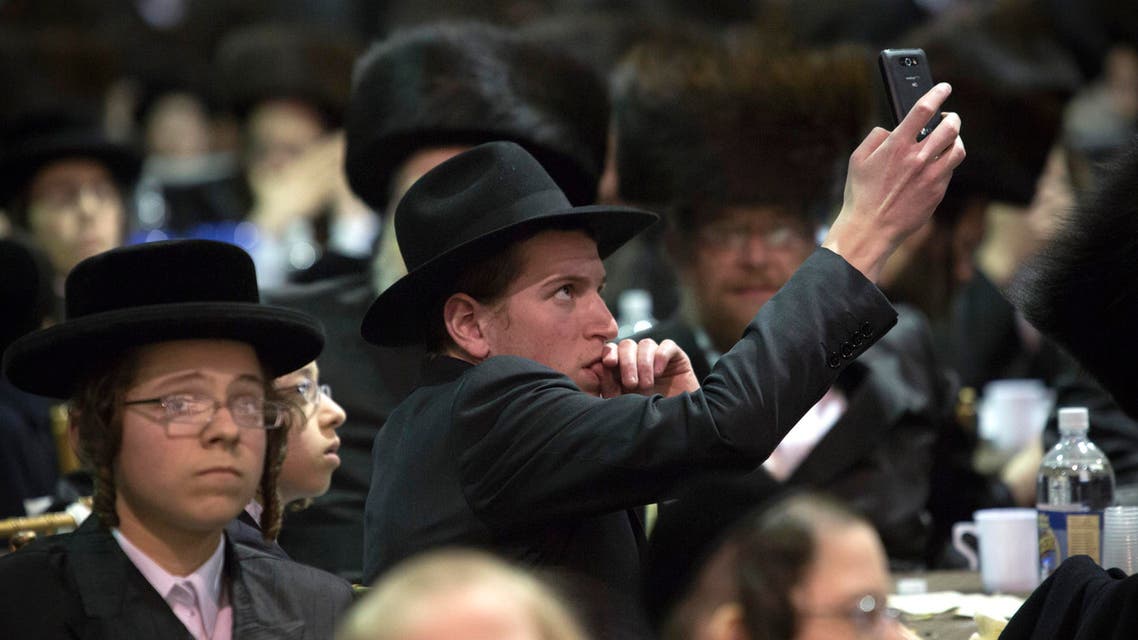 A man takes photos using his phone at a mass gathering of Satmar Hasidic Jews in New York Nov. 24, 2013. (Reuters)