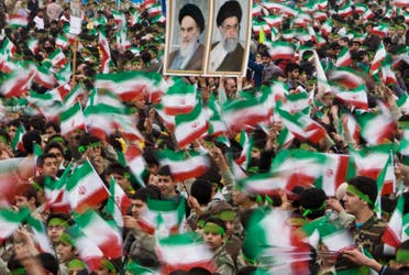 Students wave Iran's national flag as others hold pictures of Iran's Supreme Leader Ali Khamenei (R) and Iran's late leader Ruhollah Khomeini during a ceremony to mark the anniversary of Iran's 1979 Islamic Revolution on February 10, 2009. (Reuters)