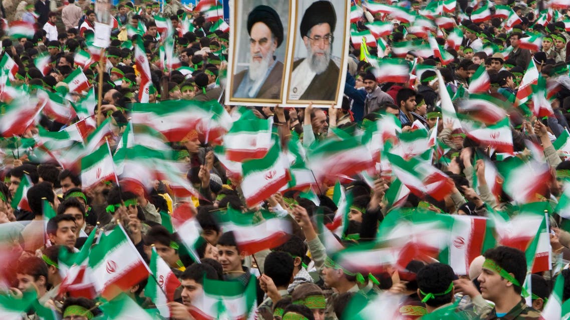 Students wave Iran's national flag as others hold pictures of Iran's Supreme Leader Ayatollah Ali Khamenei (R) and Iran's late leader Ayatollah Ruhollah Khomeini during a ceremony to mark the anniversary of Iran's 1979 Islamic Revolution, in Tehran's Azadi (Freedom) Square February 10, 2009 reut