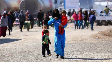 A Syrian refugee woman walks to receive her share of humanitarian aid in Quru Gusik refugee camp on the outskirts of Arbil, in Iraq's Kurdistan region, Feb. 10, 2014. (Reuters)