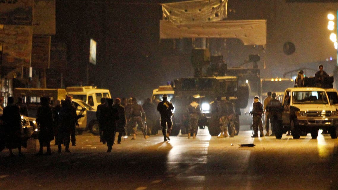 Police cars and security personnel are seen in front of the entrance to the central prison in Sanaa Feb. 13, 2014. (Reuters)