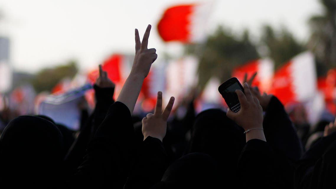 Mourners hold Bahraini flags and flash the victory sign as they march during the funeral procession for Asma Hussain, in the village of Jid Al Haj, west of Manama, February 12, 2014.  (Reuters)