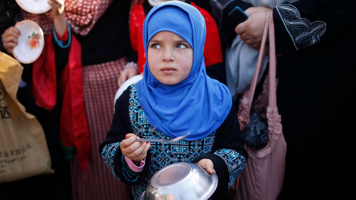 A Palestinian girl makes noise with a metal bowl and spoon as she takes part in a rally to show solidarity with Palestinian refugees in Syria's main refugee camp Yarmouk, in Gaza City January 16, 2014. Reuters