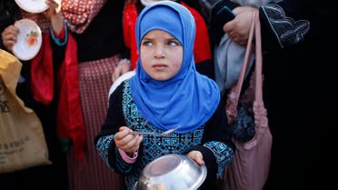 A Palestinian girl makes noise with a metal bowl and spoon as she takes part in a rally to show solidarity with Palestinian refugees in Syria's main refugee camp Yarmouk, in Gaza City January 16, 2014. Reuters