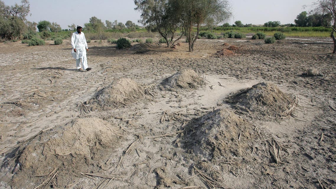 A Pakistani villager walks past nameless graves in burial grounds reserved for “karo kari” or honour killing near Daharki, 550 km (340 miles) from Karachi. Literally a “black woman”, a “kari” is a woman accused of having sex outside of marriage, while “karo” is the male version. (File: Reuters)