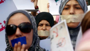 Libyan women with taped mouths take part in a silent march in support of the women who were raped during the recent war in Libya, in Tripoli Nov. 26, 2011. (Reuters)