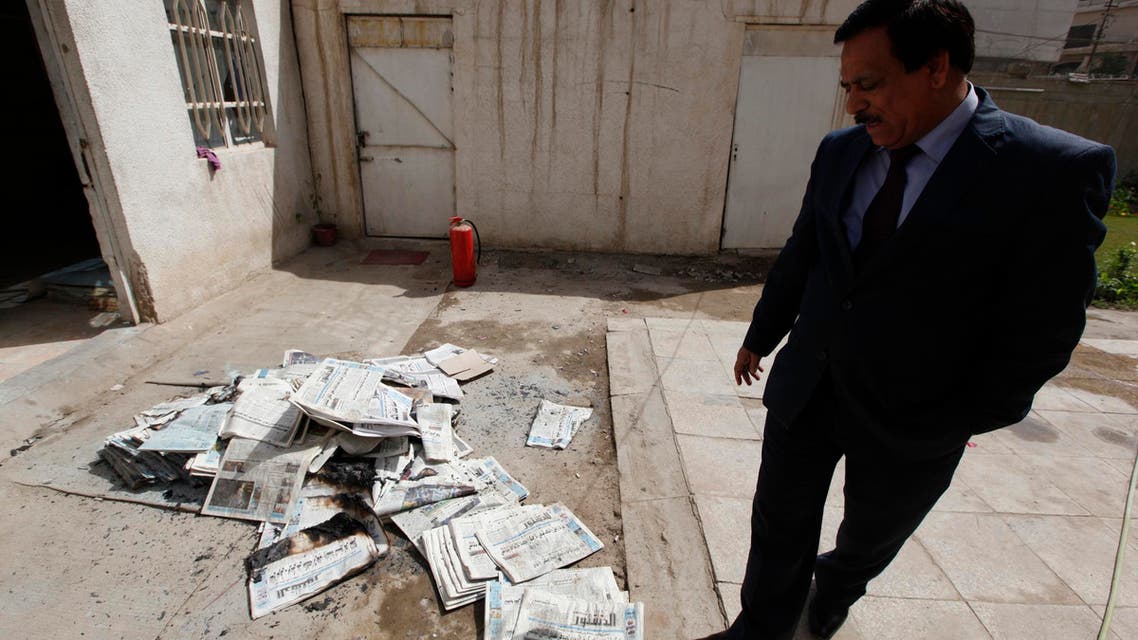 An Iraqi journalist walks past the archive newspapers burned after attack by an armed group at the newspaper's headquarters of Addustour newspaper in Baghdad, April 2, 2013. (File photo: Reuters)