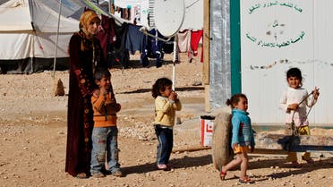 A Syrian refugee woman watches as her children play at the Zaatri refugee camp, in the Jordanian city of Mafraq, near the border with Syria Feb. 18, 2014. (