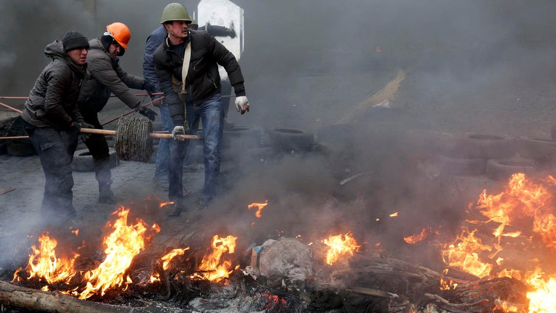 Anti-government protesters reel barbed wire around a barricade during clashes with riot police in the Independence Square in Kiev, Feb. 20, 2014. (Reuters)